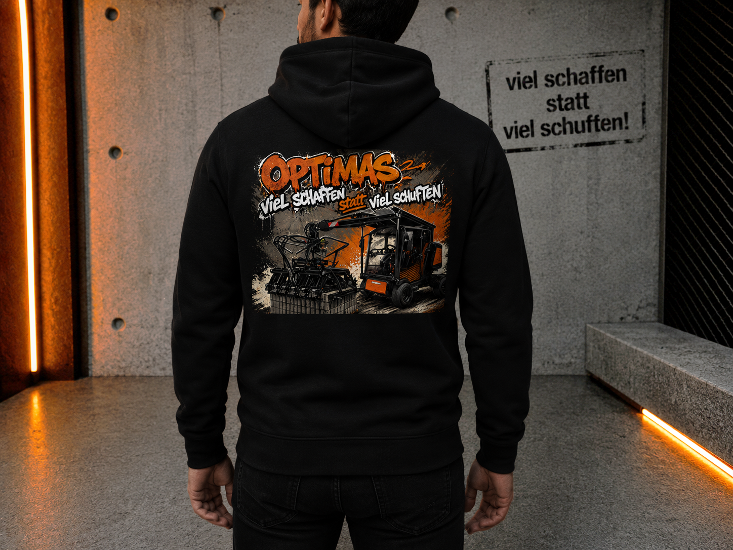 Eine Person trägt einen schwarzen Kapuzenpullover mit einem farbenfrohen Grafikdesign mit Maschinen und dem Wort „Optimas“ – Optimas.