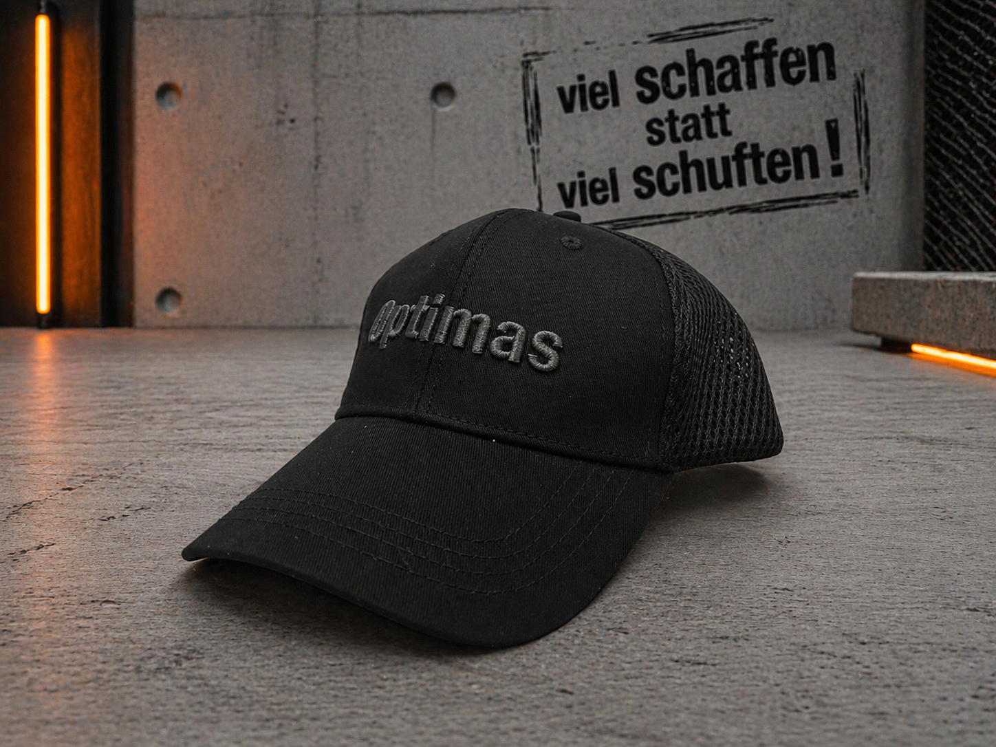 Une casquette noire avec le mot « Optimas » brodé sur le devant, placé sur une surface texturée – Optimas.