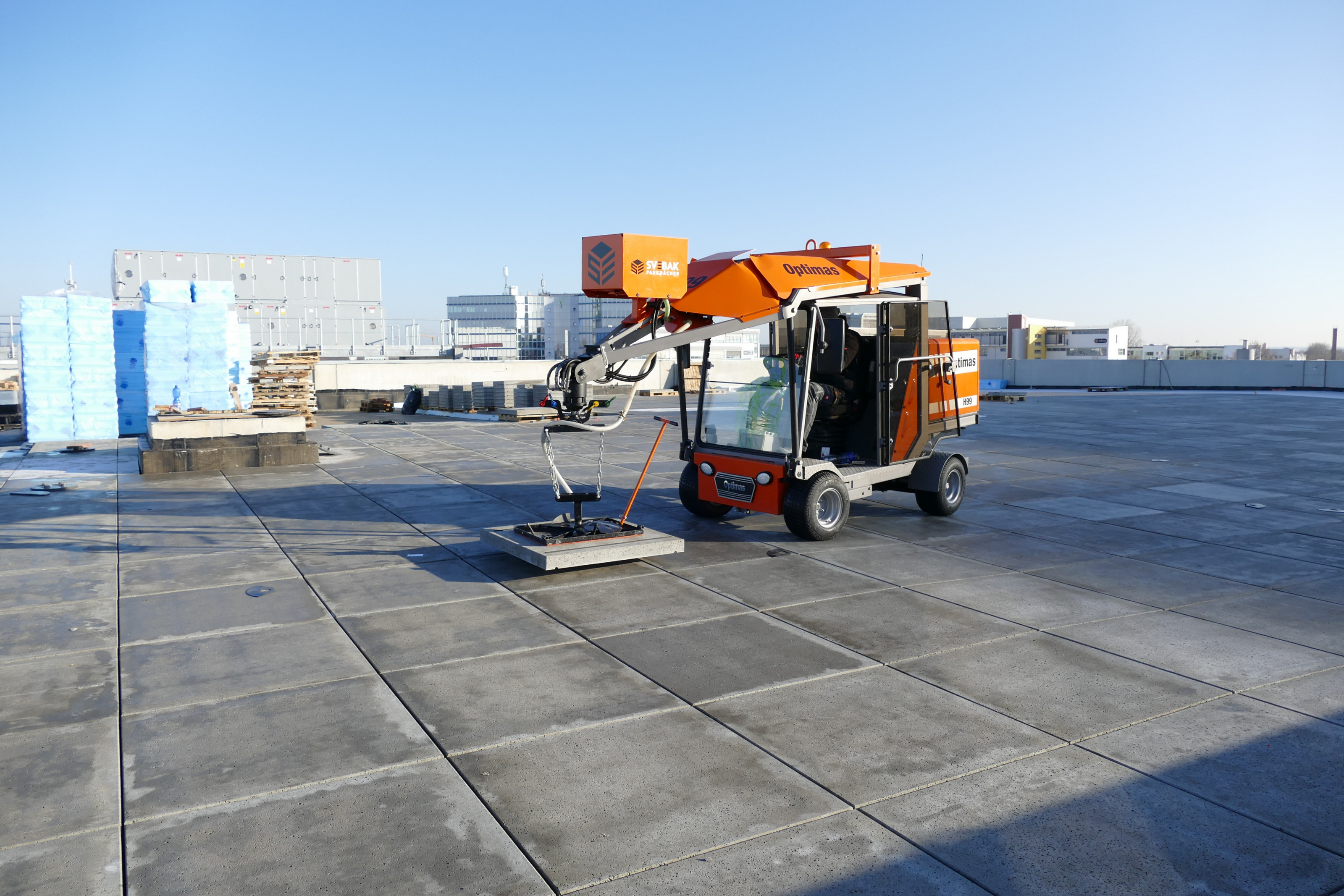 Optimas H99 Pflasterverlegemaschine auf einem Dach, konzipiert für effizientes und präzises Verlegen von Pflastersteinen und Rationalisierung des Bauprozesses – Optimas.