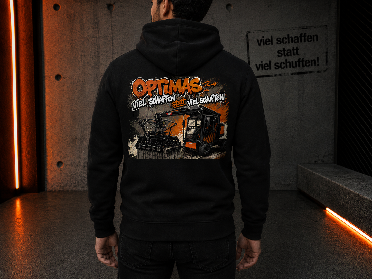 Eine Person trägt einen schwarzen Kapuzenpullover mit einem farbenfrohen Grafikdesign mit Maschinen und dem Wort „Optimas“ auf der Rückseite – Optimas.