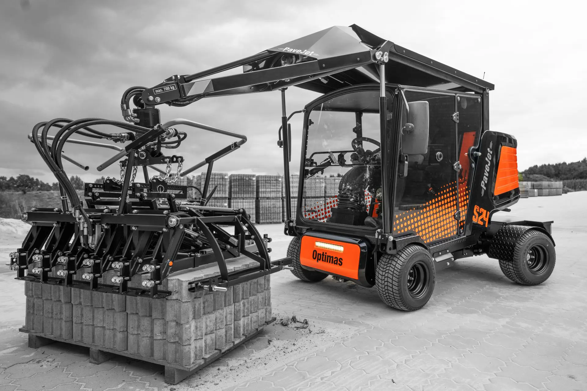 Ein kompaktes Nutzfahrzeug, ausgestattet mit hydraulischem Arm und Anbaugeräten für verschiedene Aufgaben – Optimas.