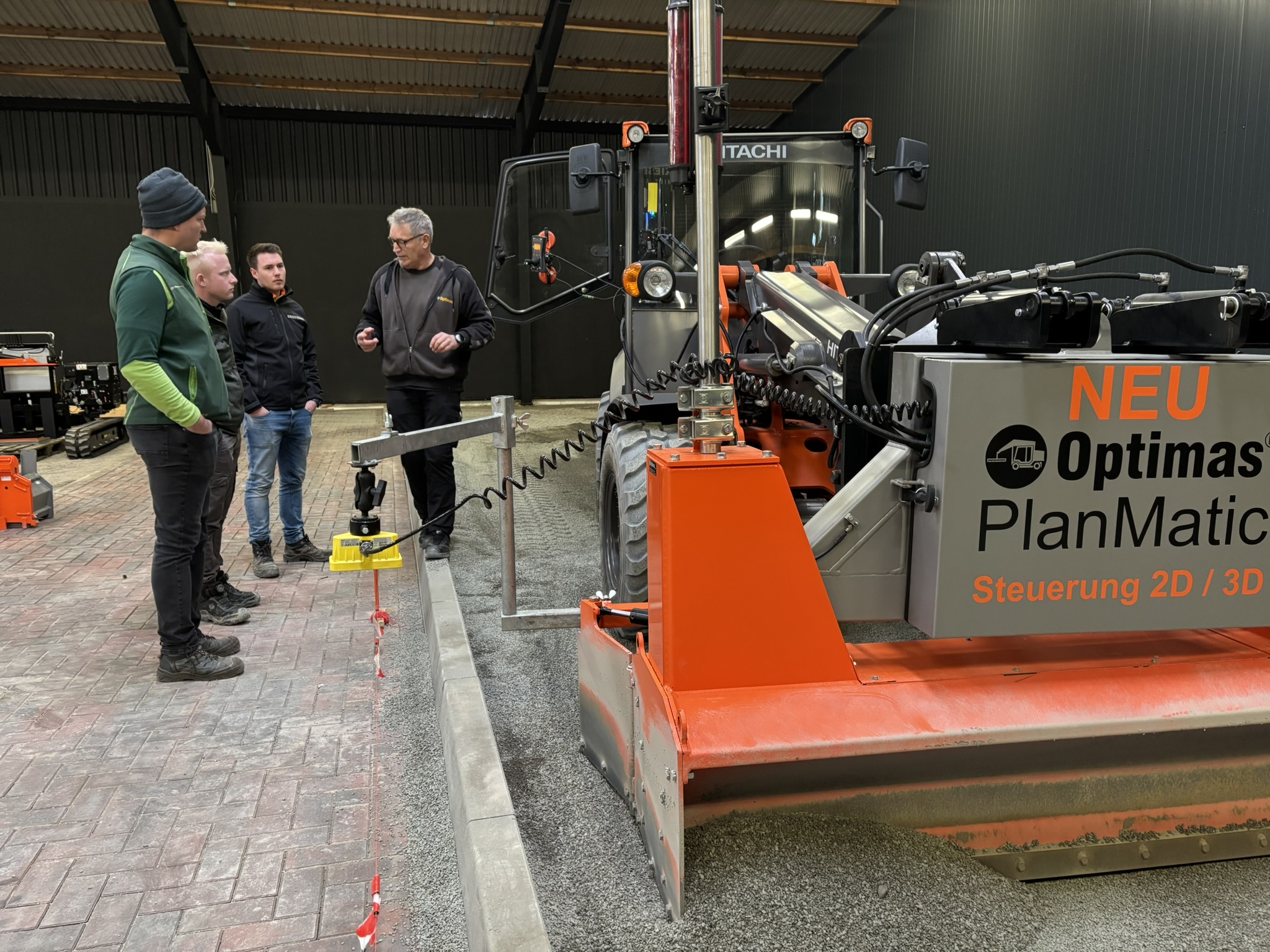 Vier Personen diskutieren in einem Workshop über die neue Optimas PlanMatic-Maschine – Optimas.