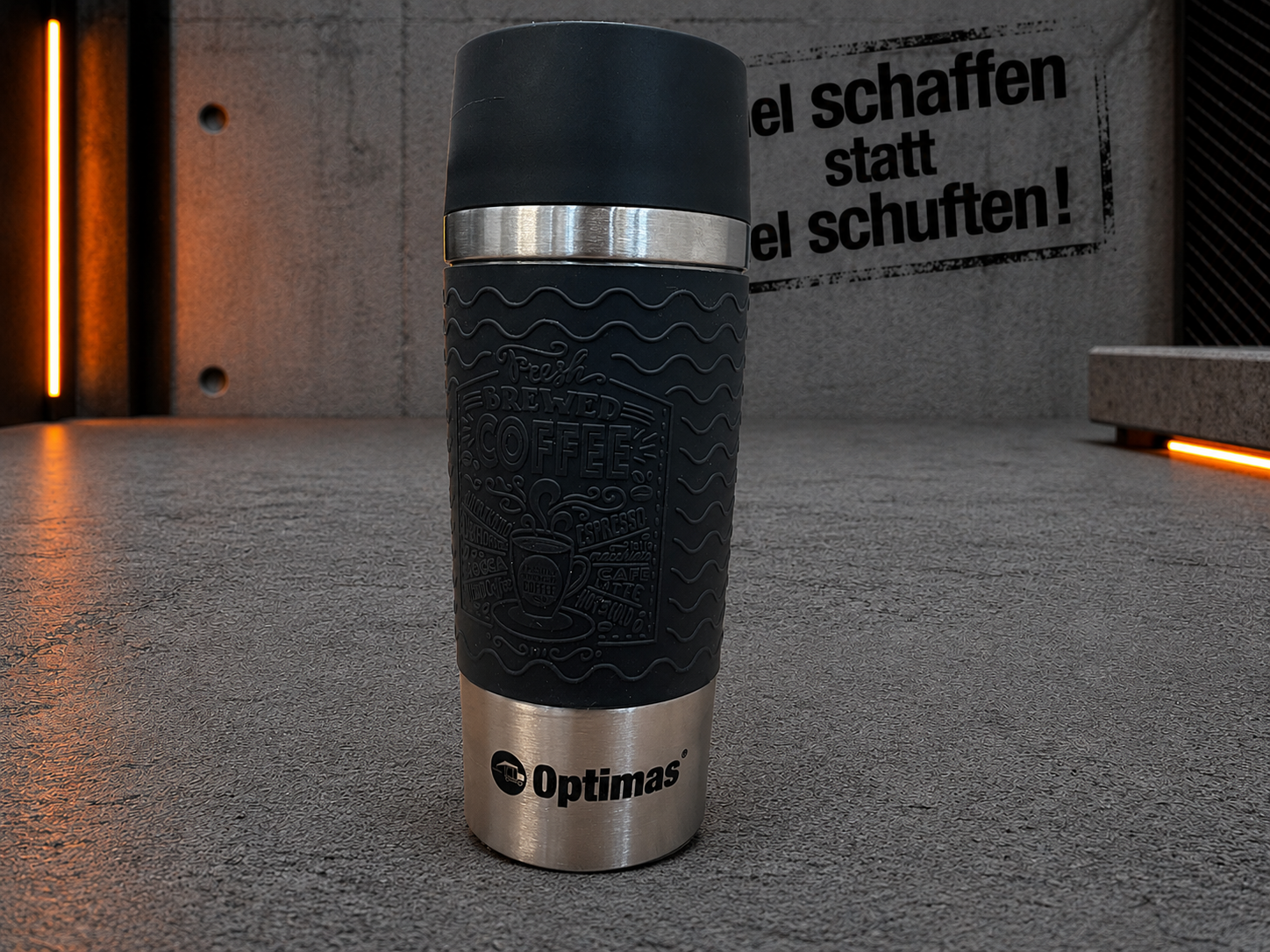 Une tasse de voyage noire élégante avec une base en acier inoxydable, présentant un design sur le thème du café – Optimas.