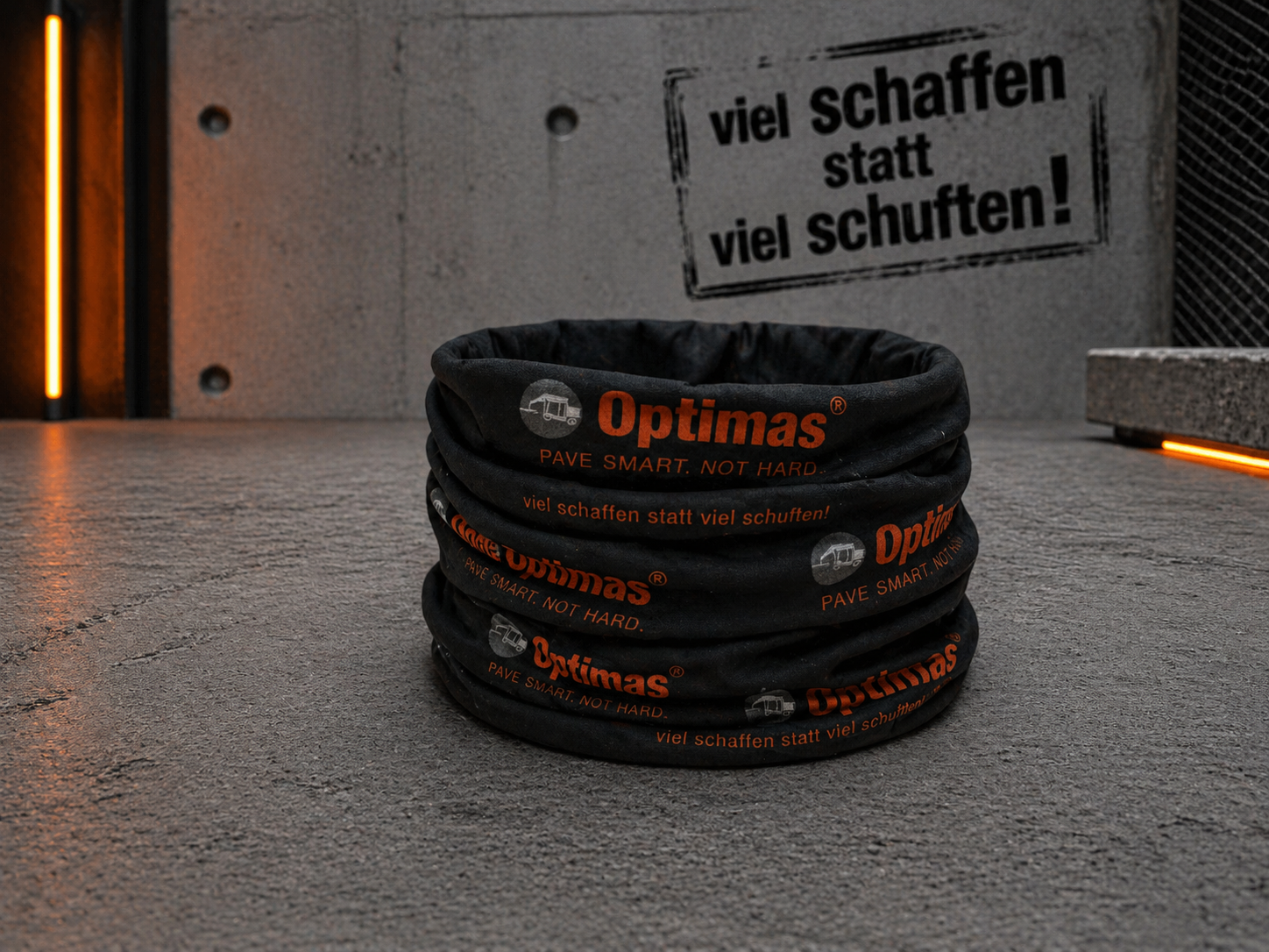Ein schwarzer Stoffartikel mit dem Optimas-Logo, das auf einer strukturierten Oberfläche angezeigt wird und Effizienz und harte Arbeit betont – Optimas.