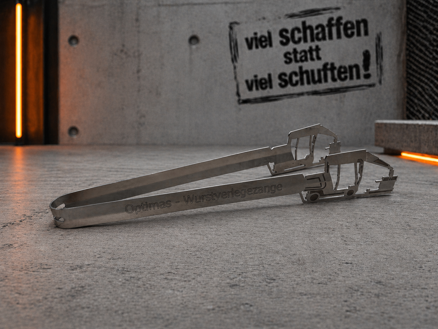 Ein Wurstlegegerät aus Edelstahl mit der Gravur „Optimas – Wurstverlegezange“ auf einer Betonoberfläche – Optimas.